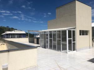 a building with glass doors on a patio at Pousada Reserva do Sahy in Mangaratiba