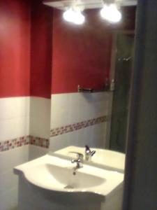 a bathroom with a white sink and a mirror at La maison des vendangeurs in Trausse