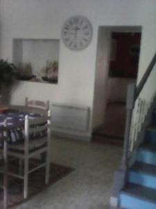 a dining room with a table and a clock on the wall at La maison des vendangeurs in Trausse +9 photos
