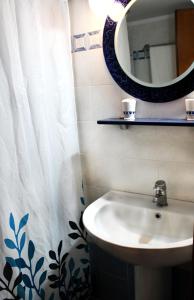 y baño con lavabo, espejo y cortina de ducha. en SOUZANA ROOMS 1, en Nea Plagia