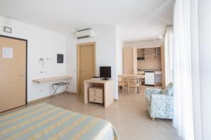 a room with a bed and a desk and a kitchen at Brianteo Hotel and Restaurant in Burago di Molgora