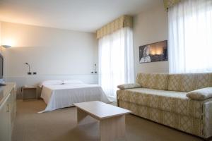Brianteo Hotel and Restaurant في Burago di Molgora: غرفة معيشة مع أريكة وسرير