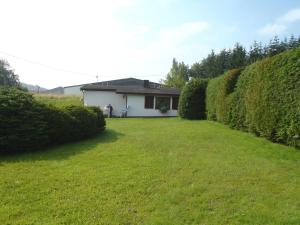 a house in a yard with a hedge at Carpe Diem in Kelberg