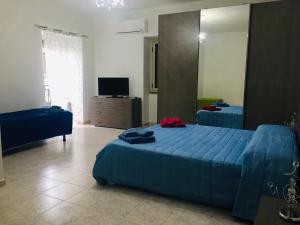 1 dormitorio con 1 cama azul y TV en Casa vacanze One, en Frascineto