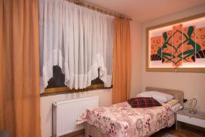 um pequeno quarto com uma cama e uma janela em Rooms Vlado em Daruvar