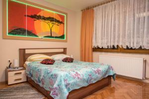 a bedroom with a bed and a painting on the wall at Rooms Vlado in Daruvar