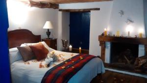 um quarto com uma cama com velas e uma lareira em Posada El Molino de San Luis em Ubaté