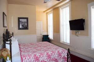 a bedroom with a bed and a flat screen tv at Grand Imperial Hotel in Silverton