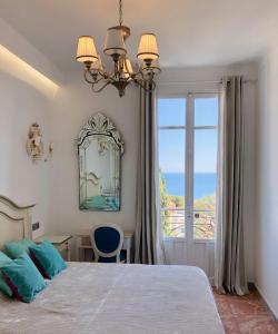 a bedroom with a bed with a view of the ocean at Hotel Normandy in Cap d'Ail