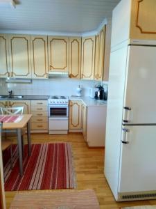 a kitchen with a white refrigerator and a table at Koti Kiviniemi in Pori