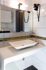ein Bad mit einem Waschbecken und einem Spiegel in der Unterkunft Hotel Royal in Frankfurt am Main