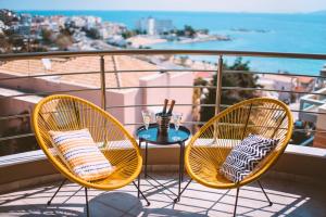 2 stoelen en een tafel op een balkon met uitzicht op de oceaan bij Sea Breeze Experience in Kavala
