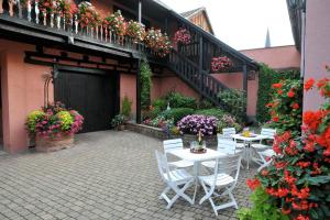 d'une terrasse avec des tables, des chaises et des fleurs blanches. dans l'établissement Gite Weyer n°3, à Bergheim