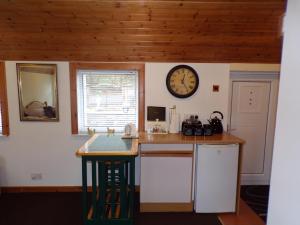 a kitchen with a counter and a clock on the wall at Groom's Cottage in Moffat