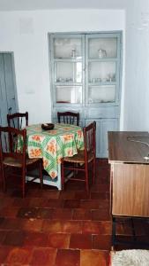 uma sala de jantar com mesa e cadeiras e um frigorífico aberto em Casa De Enguídanos em Enguídanos