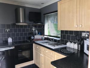 a kitchen with black counters and a stove top oven at Glangwna Holiday Park in Caernarfon