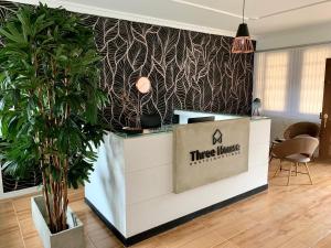 un mostrador de tres haus en una habitación con una planta en Three House Hostel Boutique, en Filandia