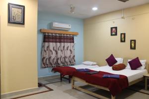 a bedroom with two beds and a window at Nisarg Resort in Guhagar