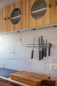 eine Reihe von Messern hängt an einer Küchenwand in der Unterkunft Goldhammer in Hagebök