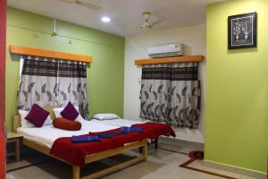 um quarto com uma cama com lençóis brancos e almofadas roxas em Nisarg Resort em Guhagar