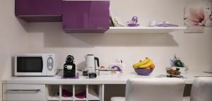 a kitchen with a counter with a microwave and bananas at Domus Paradiso City Center in Rome