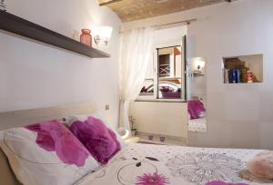 a bedroom with a bed with purple pillows and a mirror at Domus Paradiso Navona in Rome