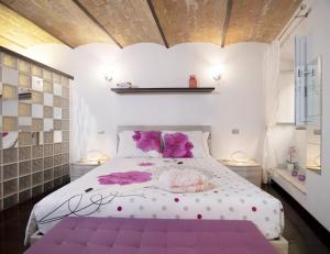 a bedroom with a large white bed with purple pillows at Domus Paradiso City Center in Rome