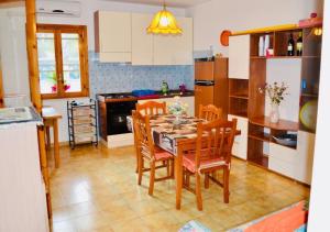 een keuken met een houten tafel en stoelen en een keuken met een fornuis bij Villetta M&M a Torre dell'Orso in Torre dell'Orso