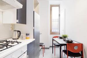 uma cozinha com fogão e mesa com cadeiras em Locanderia Roma em Roma