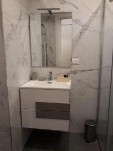 uma casa de banho branca com um lavatório e um espelho em Appartamento con vista em Milão