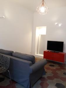 uma sala de estar com um sofá azul e uma televisão em Appartamento con vista em Milão