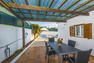a patio with a table and chairs and a pool at Villa Maria in Cala en Porter