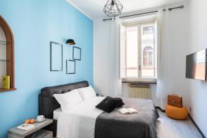 una camera blu con un letto e una finestra di A World Aparts - 32 Modena a Roma