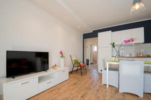 a living room with a television and a kitchen at Apartment Sun & Salt in Split