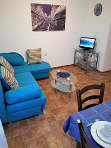 a living room with a blue couch and a table at Apartment Porat in Rovinj