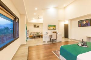 une chambre avec un lit, un bureau et une fenêtre dans l'établissement D'Polo Club & Spa Resort, à Dharamshala