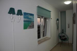 a room with two pictures on the wall and a window at Ericeira Sunset Apartment in Ericeira
