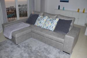a living room with a gray couch with pillows at Ericeira Sunset Apartment in Ericeira