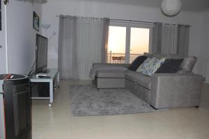 a living room with a couch and a television at Ericeira Sunset Apartment in Ericeira