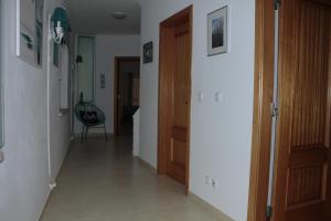 a hallway with a door and a chair in a room at Ericeira Sunset Apartment in Ericeira