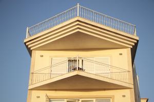 a building with a balcony and a blue sky at Ericeira Sunset Apartment in Ericeira