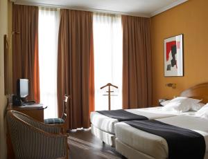 a hotel room with two beds and a window at Hotel Majadahonda in Majadahonda