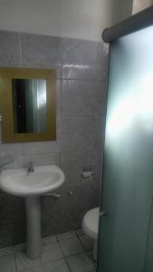 uma casa de banho com um lavatório, um WC e um espelho. em Pousada Nordestina no Recife