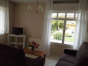 a living room with a couch and a window at Apartamentos San Pedro en Llanes in Llanes