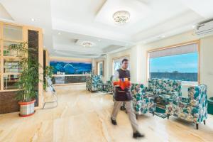 Un homme se promène dans une pièce meublée. dans l'établissement D'Polo Club & Spa Resort, à Dharamshala 73 autres photos