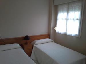 A bed or beds in a room at Apartamentos San Pedro en Llanes
