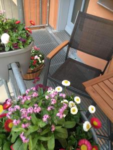 einen Balkon mit Blumen und einem Stuhl auf einer Veranda in der Unterkunft Domizil Naumburg in Naumburg