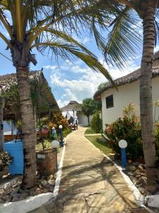 a path between two houses with palm trees at Residência Europa in Luis Correia