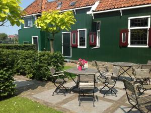 a table and chairs in front of a green building at Stay overnight at Windmill Village Zaanse Schans - Amsterdam in Zaandam +11 photos