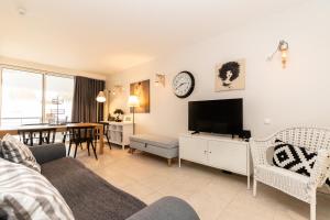 a living room with a television and a dining room at Cabanas Apartments Sea View in Cabanas de Tavira
